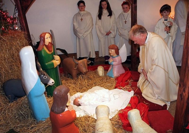 Monsignor John Byrne, PP. Portlaoise blesssing the crib with baby Jack Byrne in it during Midnight Mass in SS Peter and Paul's church Portlaoise on Christmas eve.