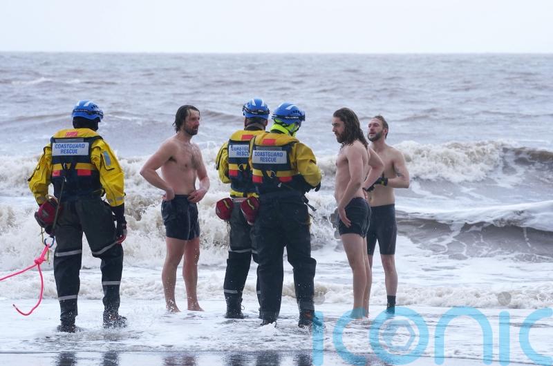 Trio defy storm warnings to strip off for sea dip