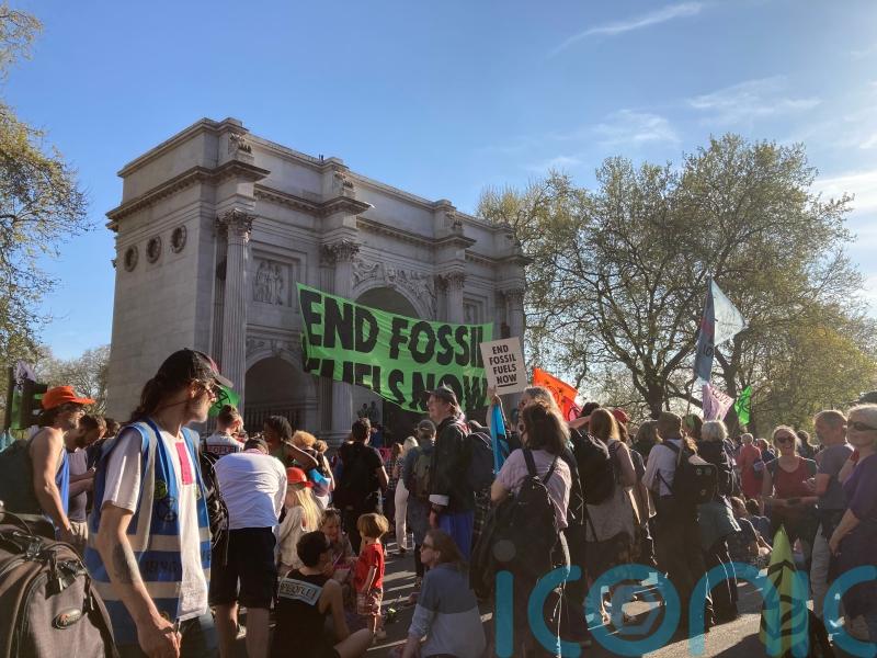 Two people climb Marble Arch amid protests against fossil fuels