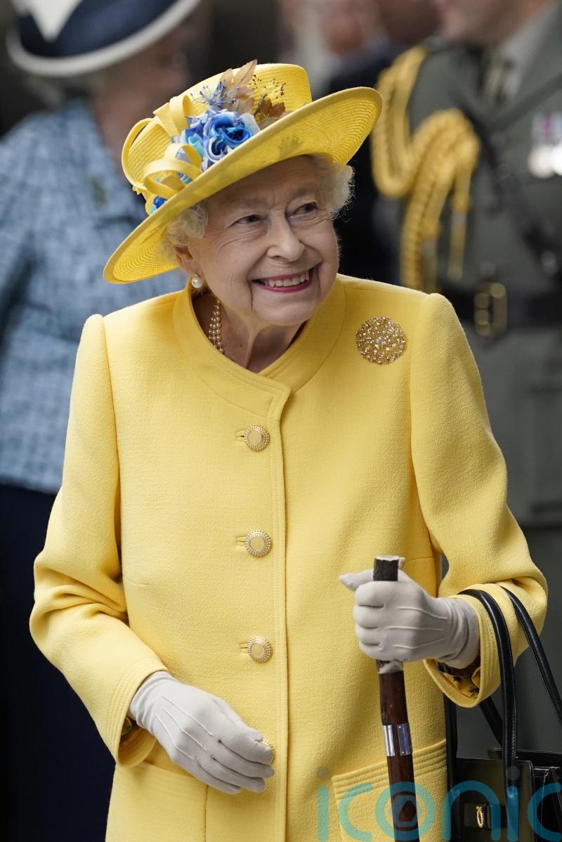 Queen beams in sunshine yellow for surprise visit to see Elizabeth line