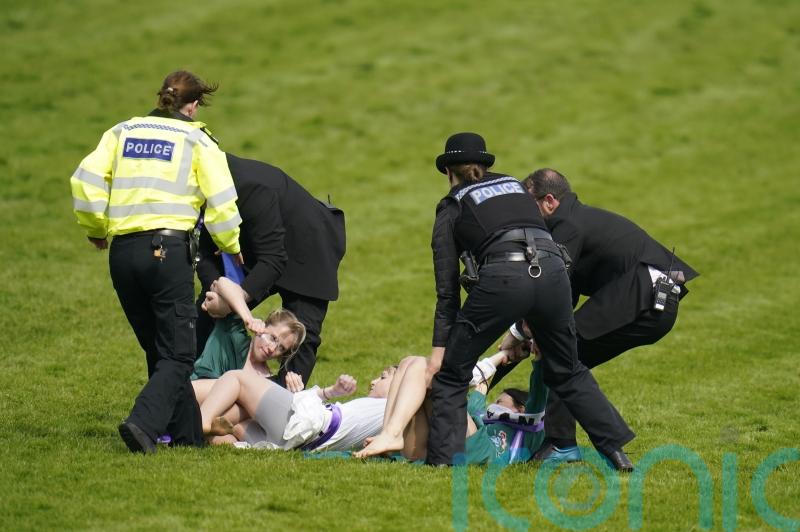 Animal activists taken away by police after running on to Epsom track
