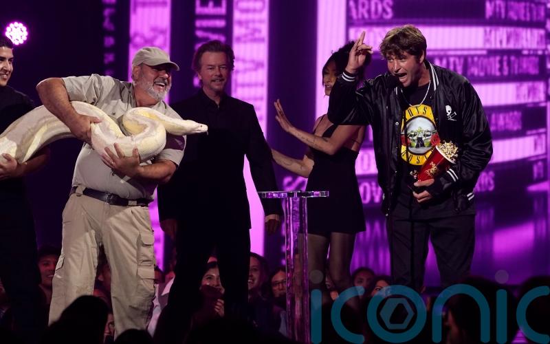 Jackass star joined onstage by enormous white snake at MTV Movie and TV awards