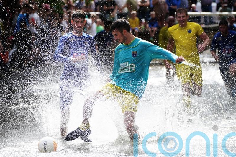 Annual river football clash goes ahead despite waterlogged pitch