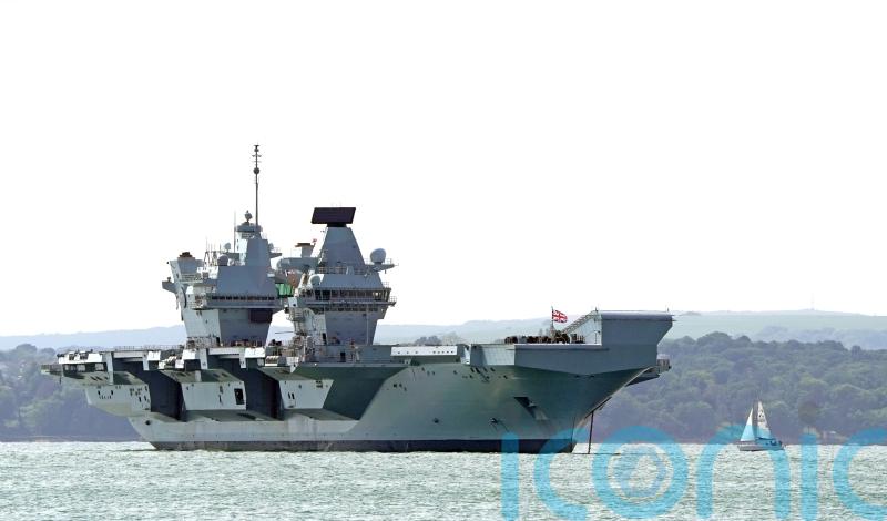 Engineers inspect damaged propeller shaft of broken down aircraft carrier