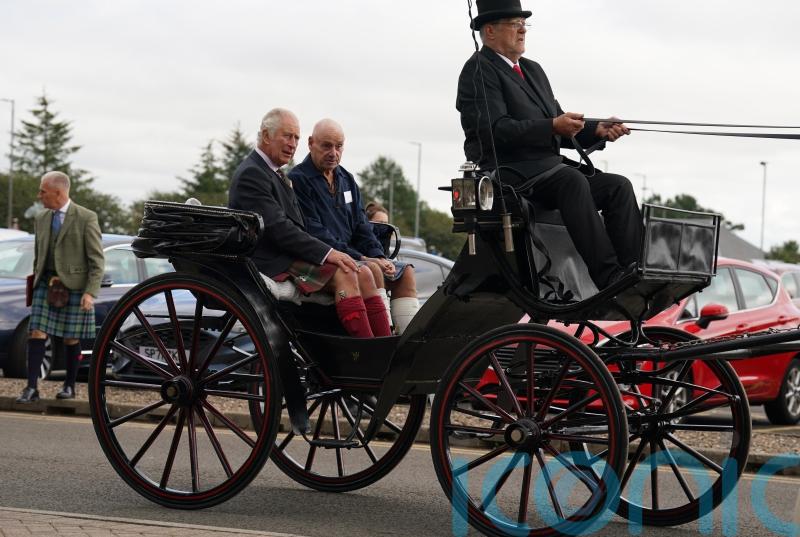 Charles strokes Clydesdale horses and enjoys carriage ride on Lanark visit