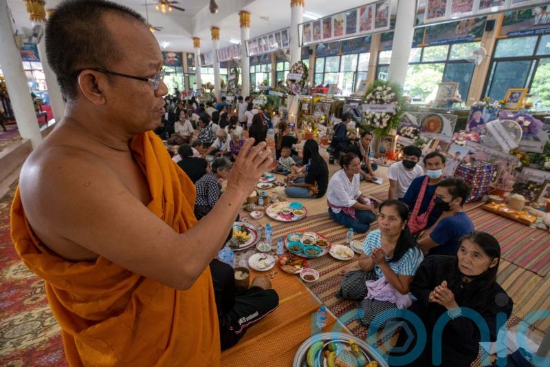 Mourners pray at Thai temple filled with keepsakes from nursery shooting victims