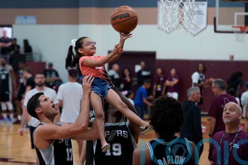 Basketball stars lift children in visit to Texas mass shooting town