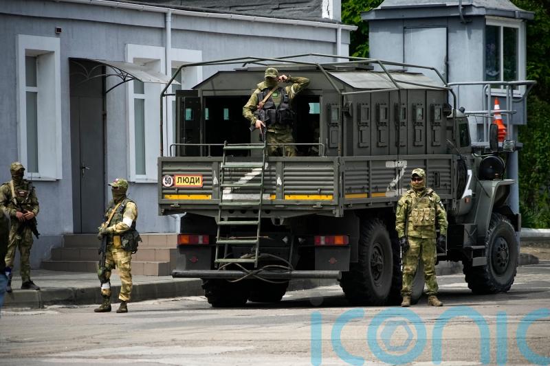 Russia says retreat from key city has begun, but Ukraine remains cautious
