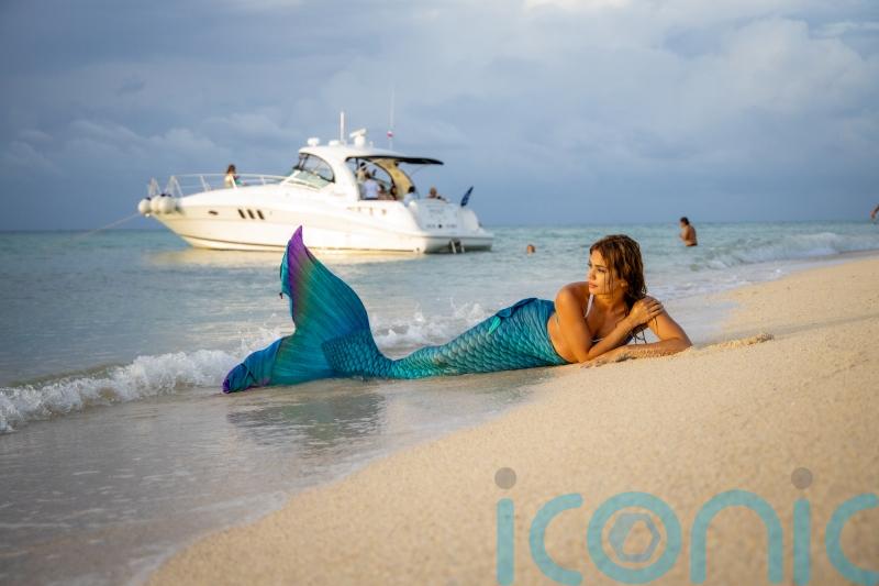 A mermaid who could not swim when she took on the role has saved a scuba diver&rsquo;s life after finding him unconscious