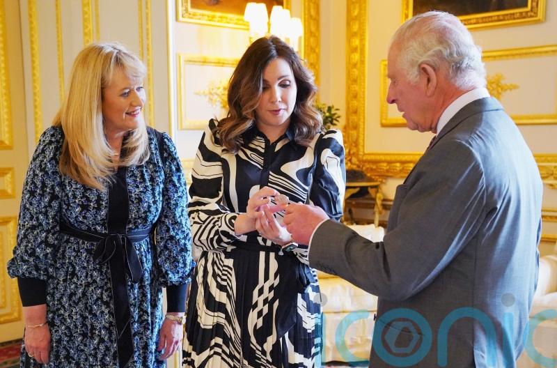 King is presented with £5 coin featuring his crowned portrait for first time