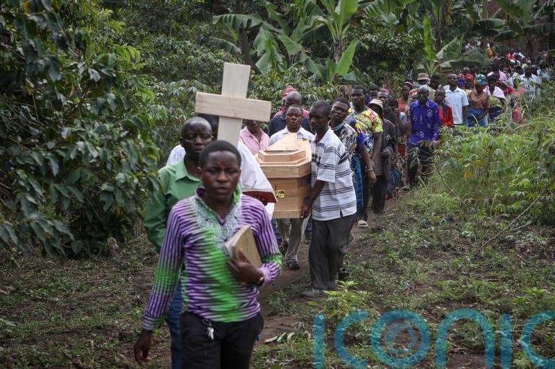 Victims are buried after rebel attack on Ugandan school leaves 42 dead