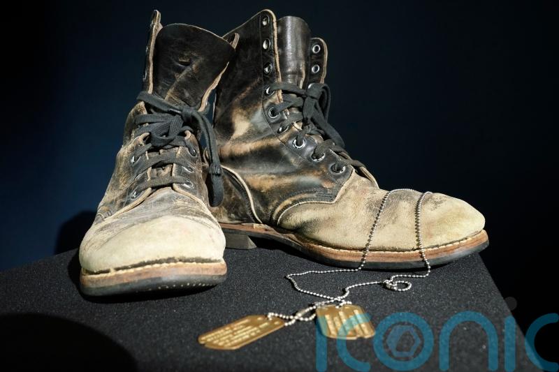 Alan Alda selling boots and dog tags from M*A*S*H