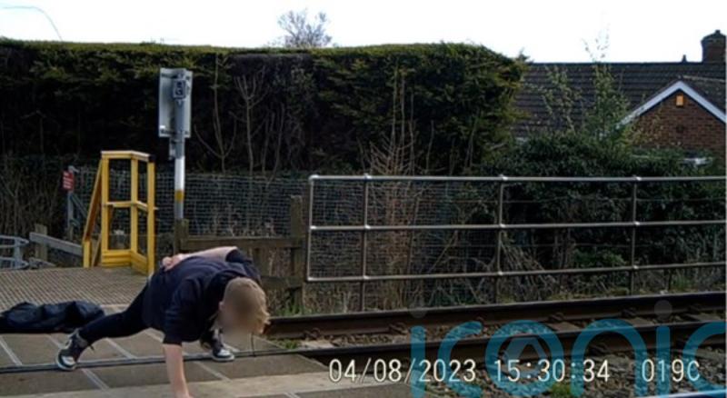 Safety warning after teenager seen doing one-armed press-up on level crossing