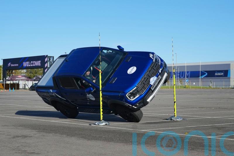 Stunt driver breaks record driving pick-up truck on two wheels through tight gap