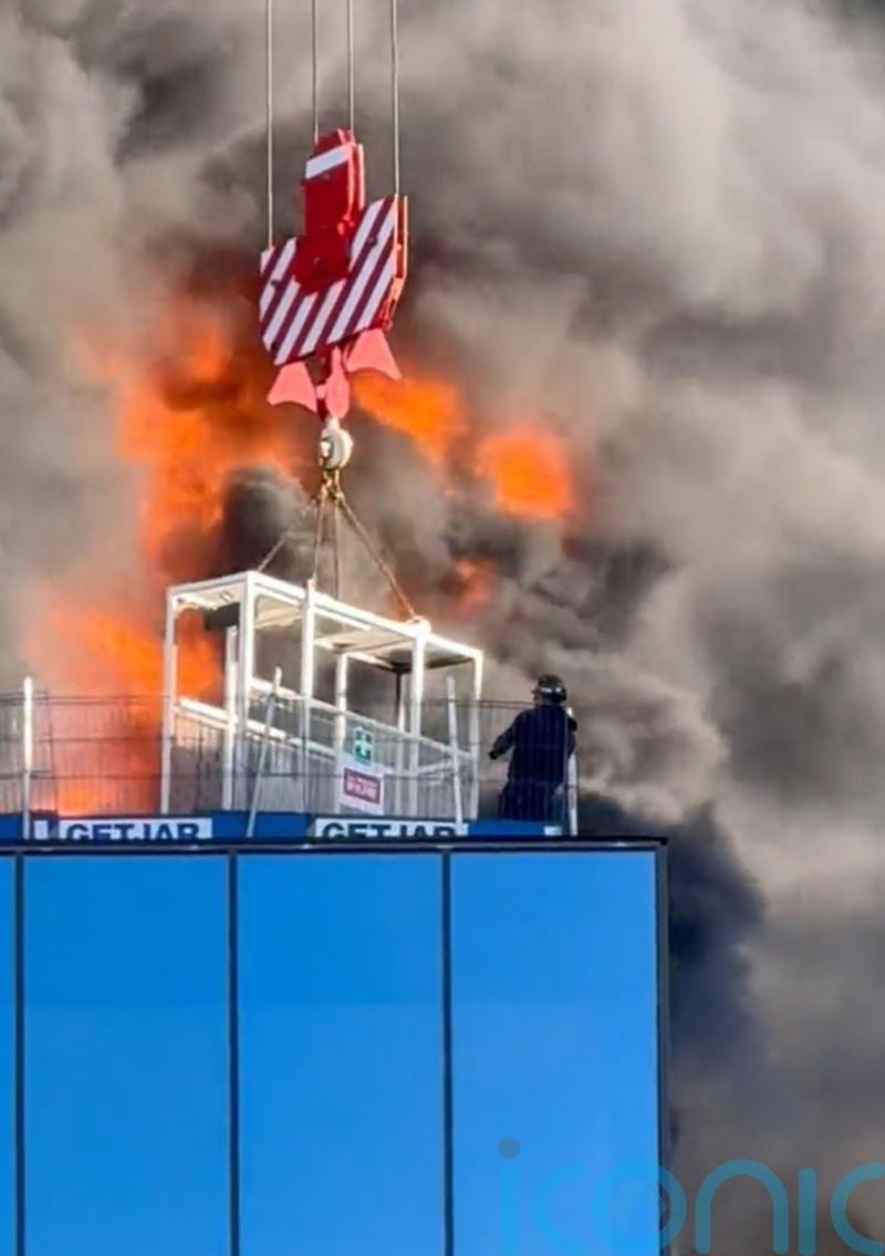 Workman trapped on burning high-rise building lifted to safety by crane