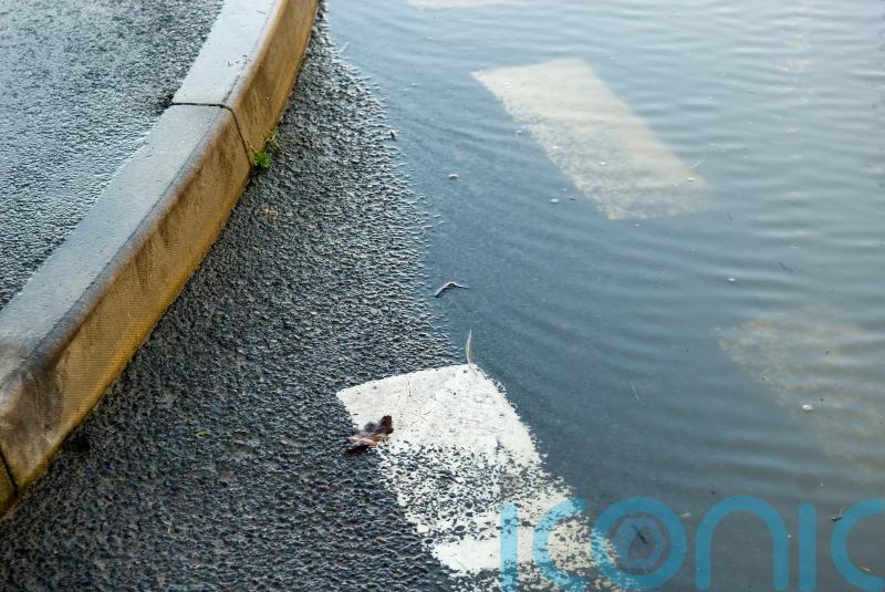 Woman canoes across carpark as floods hit London