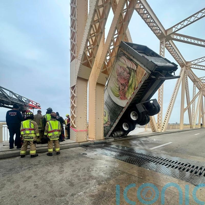 US driver rescued after crash leaves lorry dangling over side of bridge