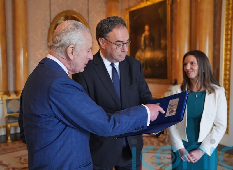 King given first notes featuring his face by Bank of England chief