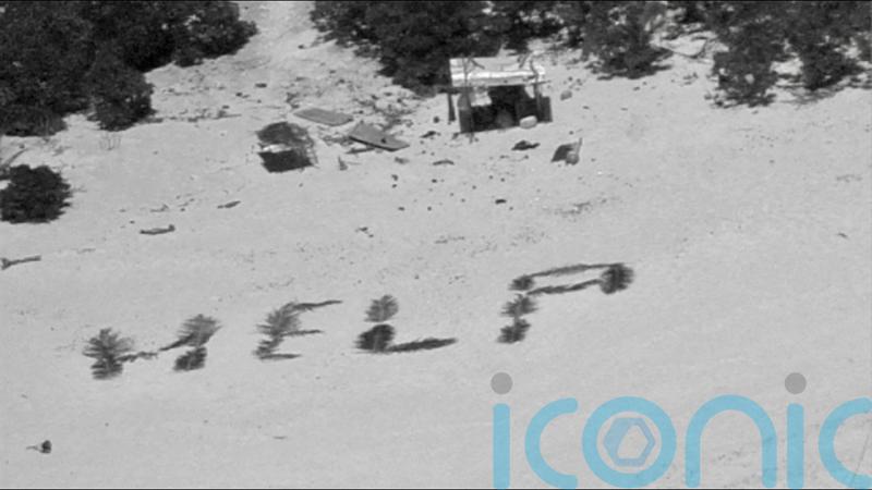 Three men rescued from Pacific island after creating ‘help’ sign on beach