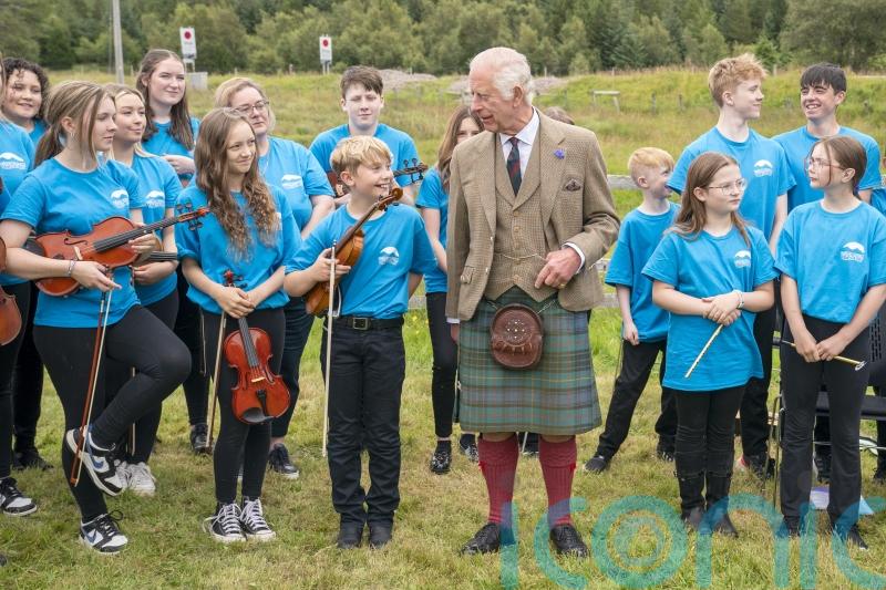 King battles midges on visit to Highland peat bog declared world heritage site