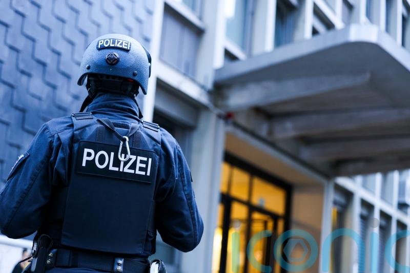 Police detain a suspect in the German knife attack that killed three