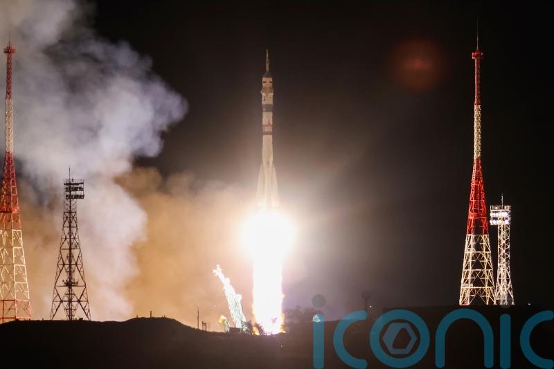 Craft carrying two Russians and an American docks at space station