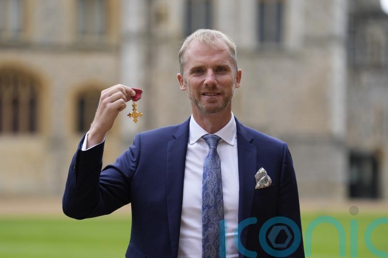 Former rugby referee Wayne Barnes jokes with William as he is made an OBE