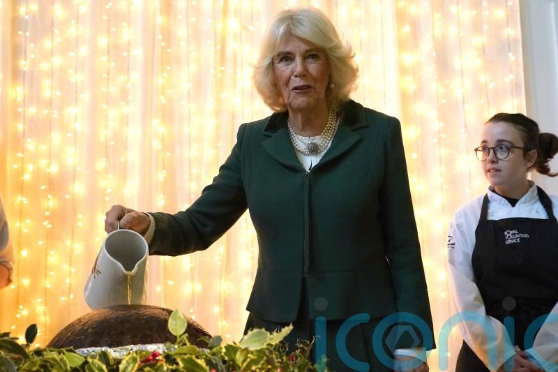 ‘Hold on to your hair’: Camilla helps light Christmas pudding at charity lunch