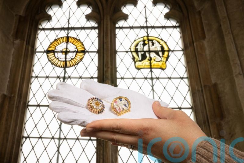 Brooches which copy London palace’s stained glass windows return home