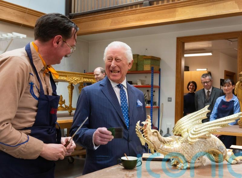 King tries his hand at gilding antique dragon ready for palace visitors