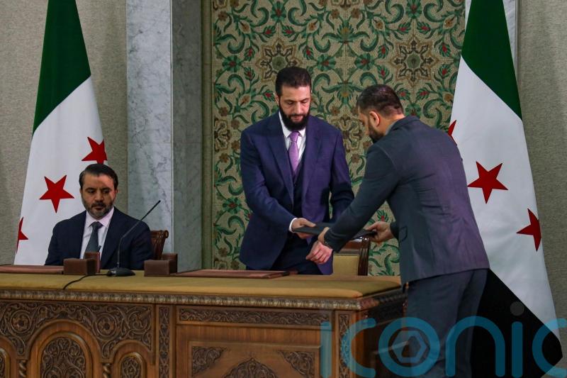 Syrian leader signs temporary constitution putting country under Islamist rule
