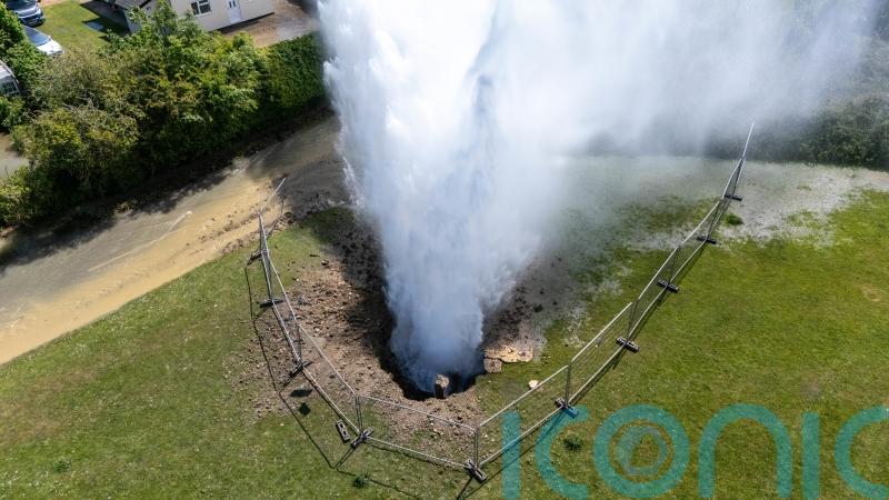 Residential street flooded as burst main shoots 100ft jet of water into the air
