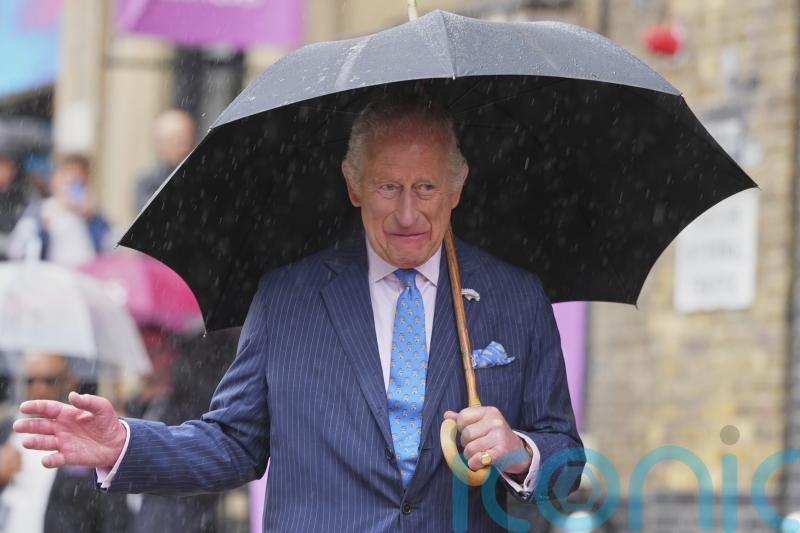 King visits London market after braving summer showers