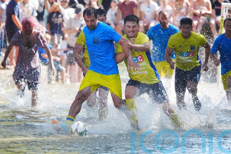 Annual river football clash goes ahead despite waterlogged pitch