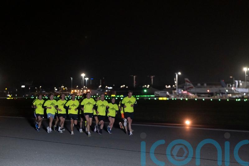 Joggers take off along runway in night-time airport fun run