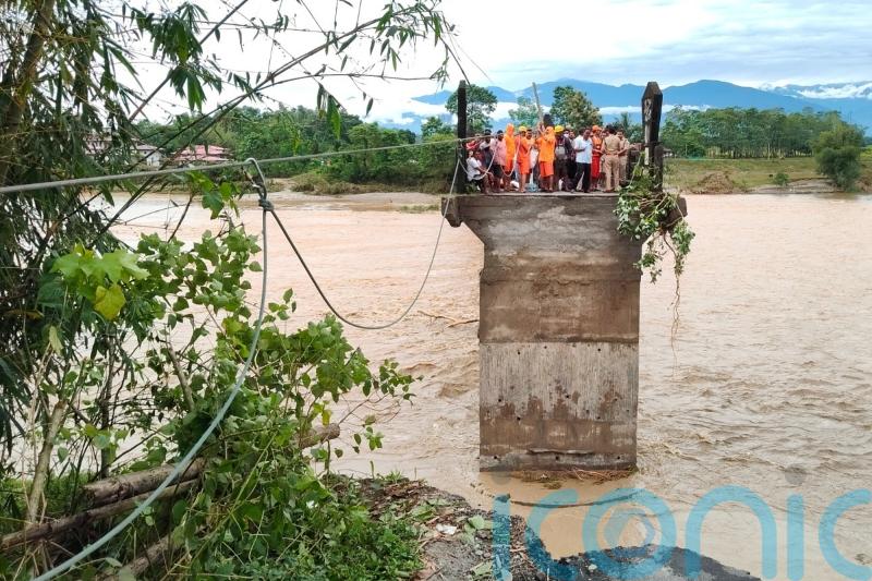 Rescuers in India search debris for missing people after landslides kill 24