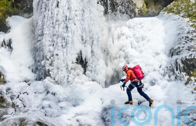 Man scales frozen waterfall in national park amid &lsquo;very rare&rsquo; conditions