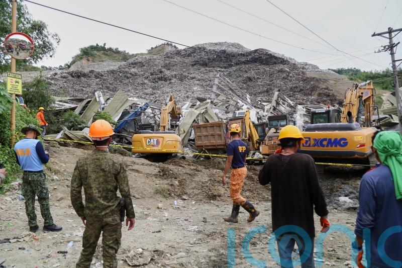 Two dead and dozens missing after mountain of rubbish collapses in Philippines