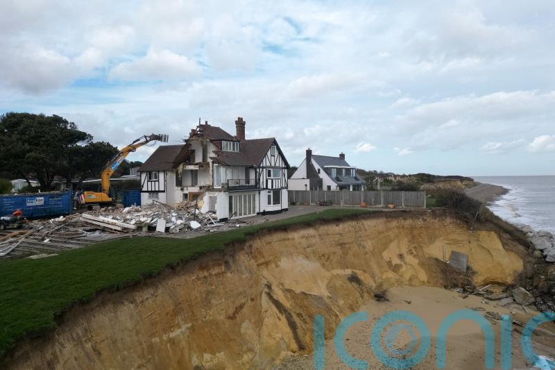 Demolition of fourth clifftop home at risk of falling into the sea begins