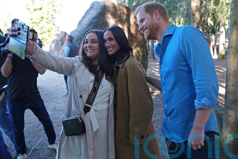 Harry and Meghan pose for selfies with public during walking tour